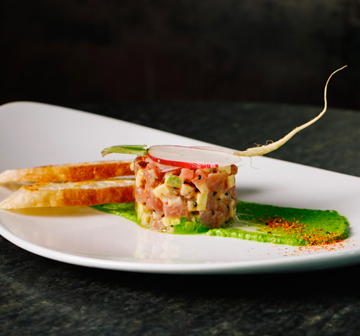 Closeup of a gourmet dish with some toasts, fruits and vegetables