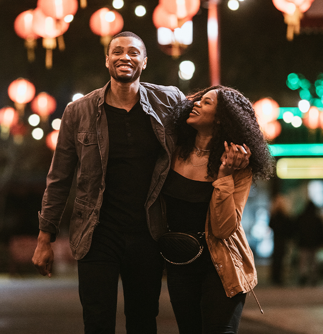 A happy couple walking on the streets at night 